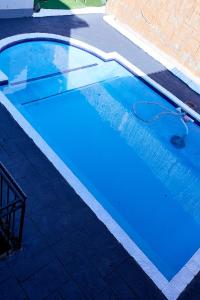 uma piscina com água azul numa garagem em Airport Royal Guest House em Kempton Park