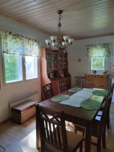 - une salle à manger avec une table, des chaises et des fenêtres dans l'établissement Huvila kosken rannalla, à Keuruu