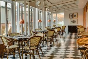 a row of tables and chairs in a room with windows at Protea Hotel by Marriott Kimberley in Kimberley