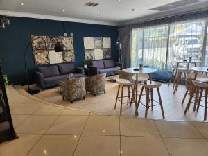 a restaurant with tables and chairs in a room at Inani Hotel Gallagher in Midrand