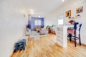 a living room with a kitchen and a living room with a table at Plum Apartment in Podgorica