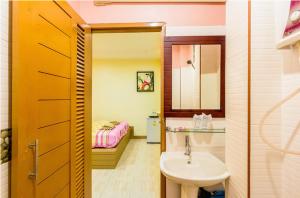 a bathroom with a sink and a toilet and a bed at BaanRabiangnam kohlarn in Ko Larn