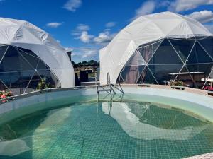 una piscina con 2 cúpulas y una piscina en LoveLand Farm Kupolai 