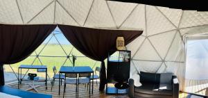 a room with a table and chairs in a yurt at LoveLand Farm Kupolai 