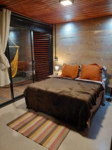 a bedroom with a large bed with orange pillows at Casa da Serra in Cavalcante