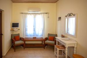 uma sala de estar com uma mesa e cadeiras e uma janela em Amphithea Fragokastelo-Skaloti em Skalotí