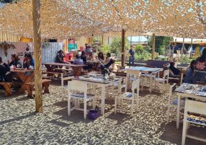 Casa La Laguna - Pichilemu في بتشيلمو: مجموعة من الناس يجلسون على الطاولات تحت خيمة
