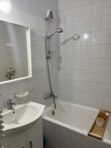 y baño con ducha, lavabo y bañera. en Kalmár Apartman, en Veszprém