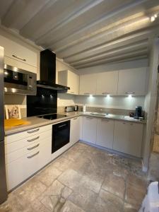 una cucina con armadietti bianchi ed elettrodomestici neri di l'appart de vic a Honfleur