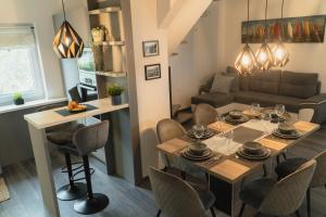 a dining room and living room with a table and chairs at Panoráma Borbirtok in Mencshely