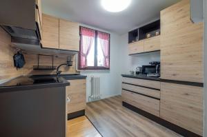 a kitchen with wooden cabinets and a sink at GuestHost - Marilyn Apartment tra centro e mare in Pesaro +7 photos