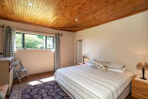 sypialnia z łóżkiem i drewnianym sufitem w obiekcie Ripon Country Cottage w mieście Himeville