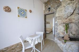 einen Tisch und Stühle in einem Zimmer mit einer Steinmauer in der Unterkunft Appartamenti da Clarissa in Macari