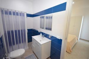 マカリにあるAppartamenti da Clarissaの青と白のバスルーム(トイレ、シンク付)