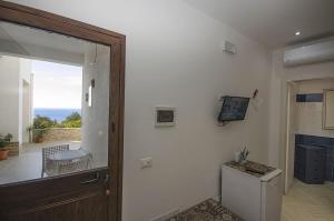 a room with a hallway with a refrigerator and a window at Appartamenti da Clarissa in Macari