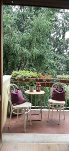 een patio met 2 stoelen en een tafel met paarse kussens bij Appartamento Viale Puccini - Free Gated Parking - 3 Minutes from Center in Lucca