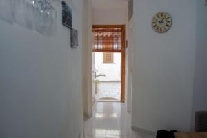 una stanza con un orologio sul muro e un corridoio di Adriatic Suite - Casa vacanze a SantʼAndrea