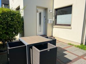 ein Tisch und zwei Mülltonnen vor einem Haus in der Unterkunft Meike 2 - Ebenerdige Wohnung mit Terrasse und kleinem Garten in Wangerooge + 6 Fotos