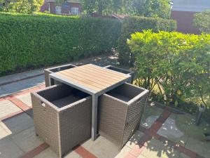 einen Picknicktisch und zwei Korbstühle auf einer Terrasse in der Unterkunft Meike 2 - Ebenerdige Wohnung mit Terrasse und kleinem Garten in Wangerooge