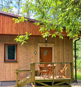 a cabin with a table and chairs on the porch at Apartmány Kocanda in Jesenice