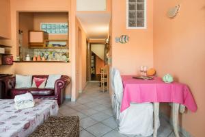 sala de estar con mesa y mantel rosa en LariBiancos Cagliari CENTRO STORICO, en Cagliari