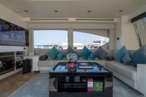 Holiday yacht in Dubai في دبي: غرفة معيشة مع أريكة وطاولة