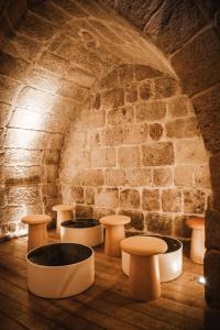 een kamer met tafels en stoelen voor een bakstenen muur bij The Central House Porto Ribeira in Porto