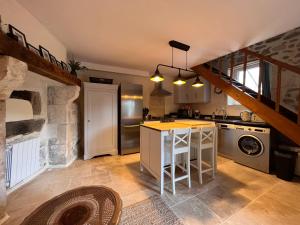 uma cozinha com um lavatório e um fogão forno superior em La Pêche em Piégut-Pluviers
