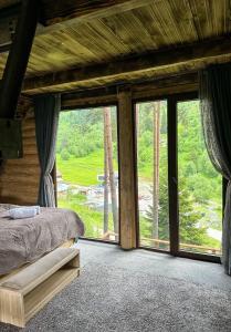 a bedroom with a bed and a large window at Hut In Hatsvali in Mestia