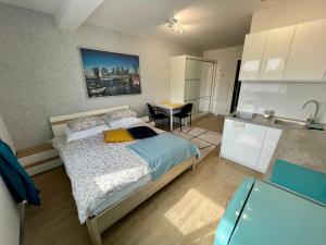 1 dormitorio con 1 cama y cocina con mesa en Arenaapartments, en Gdansk
