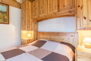 een slaapkamer met een bed en houten kasten bij Baita Bocheto in Levico Terme