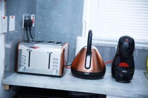 a toaster and a toaster sitting on a counter at Impeccable 1-Bed Apartment in Harrow in Harrow