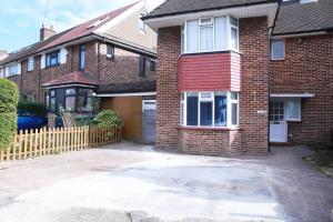 a brick house with a driveway in front of it at Impeccable 1-Bed Apartment in Harrow in Harrow