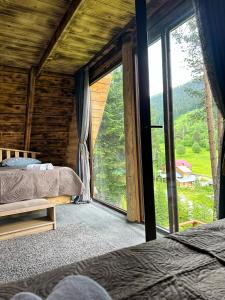 a bedroom with two beds and a large window at Hut In Hatsvali in Mestia