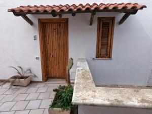 una casa bianca con una porta in legno e un portico di Adriatic Suite - Casa vacanze a SantʼAndrea