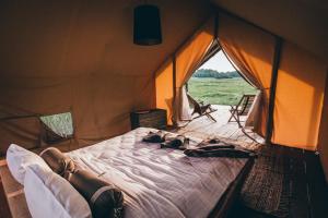 ein Bett in einem Zelt, auf dem die Leute liegen in der Unterkunft Muuski glempings in Korneti
