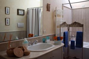 y baño con lavabo, espejo y bañera. en L'Oleandro sul Lago d'Iseo B&B en Sulzano
