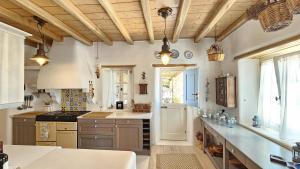 a kitchen with wooden ceilings and a counter top at Villa Karam in Mýkonos City