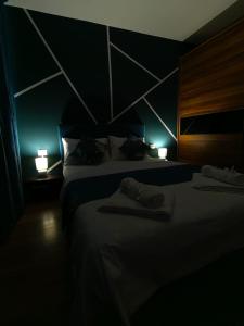 a dark room with two beds and two lights at Noua Apartment in Braşov
