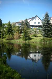 widok na jezioro z domem w tle w obiekcie Pensjonat Willa Edyta w mieście Mrągowo