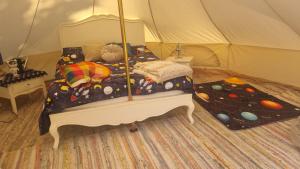 a bedroom with a bed in a tent at Stargazer bell tent secret garden glamping 