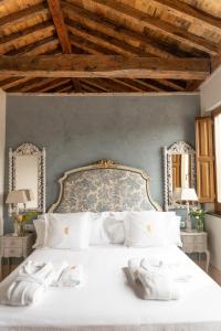 a bedroom with a white bed with towels on it at La Corrala del Realejo in Granada +160 photos