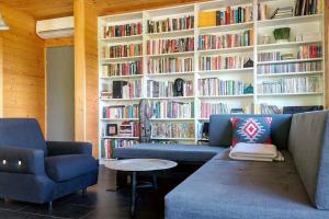 a library with two couches and a book shelf with books at St. Barbara Hideaway in Škofja Loka