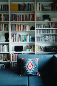 a living room with a couch and book shelves with books at St. Barbara Hideaway in Škofja Loka