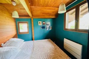 1 Schlafzimmer mit einem Bett mit blauen Wänden und 2 Fenstern in der Unterkunft Bright chalet with terrace and garden in Briançon in Briançon