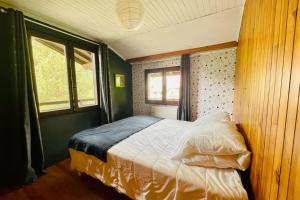 ein Schlafzimmer mit einem Bett in einem Zimmer mit Fenstern in der Unterkunft Bright chalet with terrace and garden in Briançon in Briançon