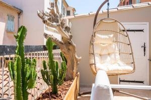 a swinging chair on a balcony with cactus at Ile de Porquerolles, KerMarc, appartement lumineux avec grande terrasse in Porquerolles