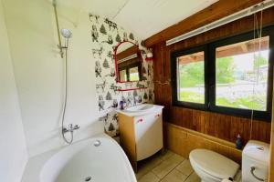 ein Badezimmer mit einer Badewanne, einem WC und einem Waschbecken in der Unterkunft Bright chalet with terrace and garden in Briançon in Briançon