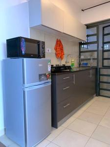 y cocina con nevera y microondas. en Modern 1-Bedroom Unit 5 mins from CBD en Nairobi