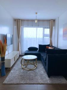 sala de estar con sofá azul y mesa en Modern 1-Bedroom Unit 5 mins from CBD en Nairobi